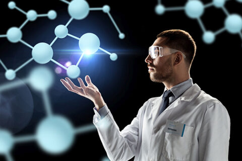 Das Bild zeigt einen Wissenschaftler in Laborkittel und Schutzbrille, der einige Computer generierte Molekülketten in der Hand hält.