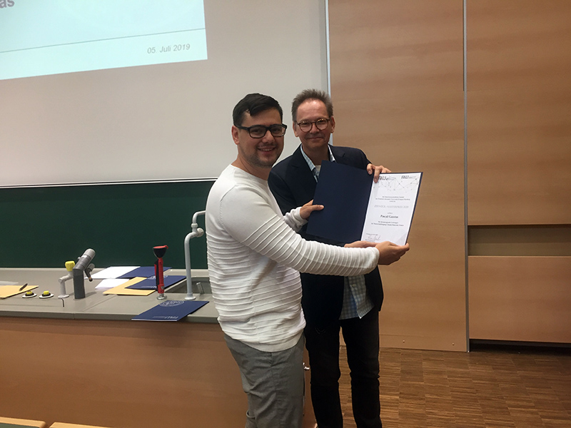Pascal Gazetas (l) erhält von Prof. Dr. Drewello den Zerweck-Masterpreis (Foto: FAU)