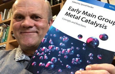 Prof. Dr. Sjoerd Harder hält sein Buch "Early Main Group Metal Catalysis" in die Kamera