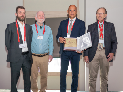 Das Foto zeigt Prof. Dr. Guldi mit drei Teilnehmern des ICPP. In den Händen hält Prof. Guldi die Urkunde des Awards