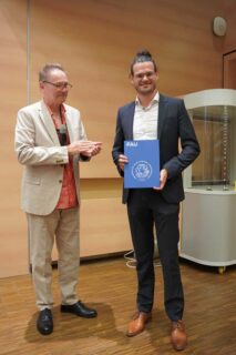 Prof. Dr. Thomas Drewello (l.) übergibt den Zerweck-Promotionspreis an Dr. Stephan Müssig. (Foto: Thomas Hofmann, FAU)