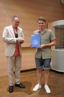 Prof. Dr. Thomas Drewello (l.) übergibt den Zerweck-Lehramtspreis an Nicolas Wellnhofer. (Foto: Thomas Hofmann, FAU)