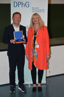 Prof. Dr. Peter Gmeiner (links) hält die Medaille in der Hand. Neben ihm steht Prof. Dr. Dagmar Fischer, Präsidentin der DPhG